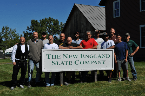 team holding the new england slate company sign